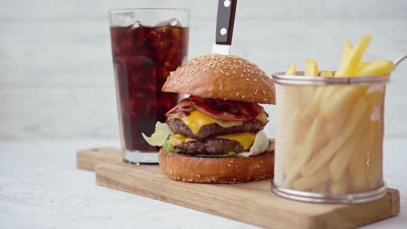 Fresh Tasty Burger Served with Soda and French Fries on White Table