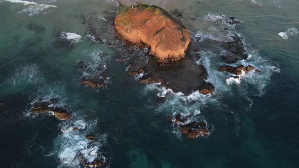 Multiple large rocks in the shallow water of the south pacific ocean. South American beach during su