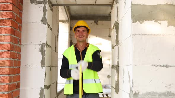 Construction worker at construction site measures the length of the window opening