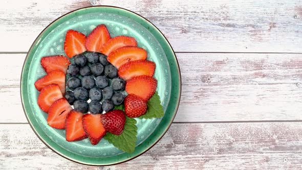 Vegetarian Healthy Dessert with Strawberries and Blueberries Rotate Slowly on Turntable