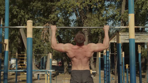 Athletic Man Making Pull-up Exercises on Crossbar