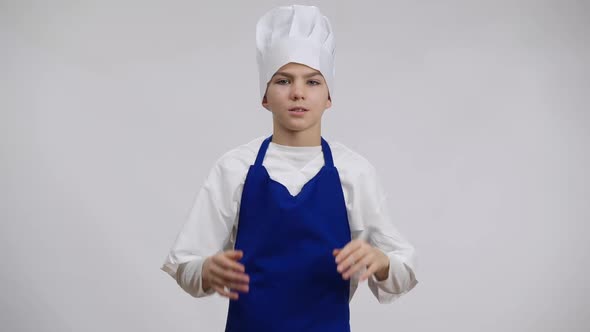 Stressed Little Cook Rubbing Temples Pulling Chef Hat on Head