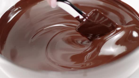 Closeup Stirring Mixing Milk Melted Chocolate in Glass Bowl on White Background