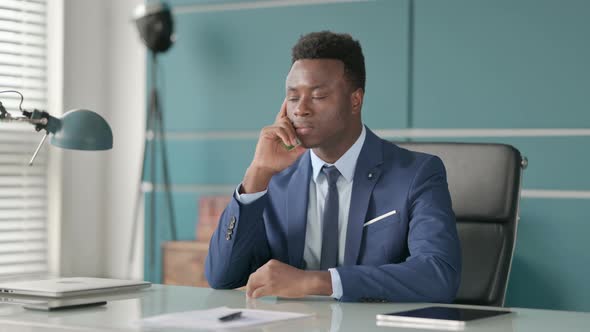 Pensive African Businessman Thinking While Sitting in Office