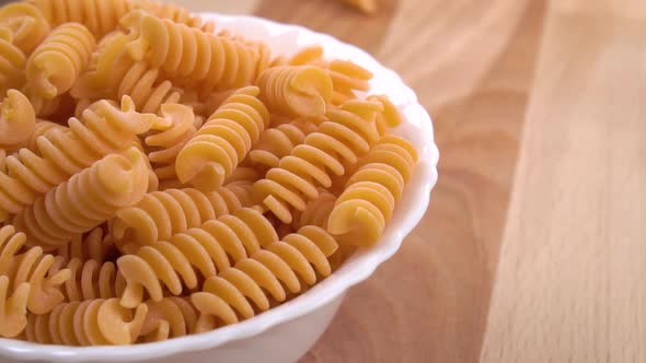 Whole grain red lentil uncooked pasta. Falling raw macaroni in slow motion