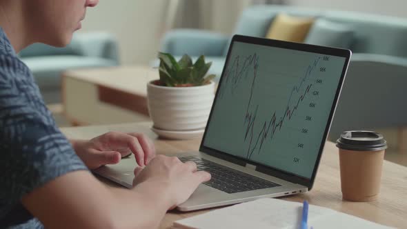 Businessman Looking At Financial Data With Graphics And Charts While Work On A Laptop Computer