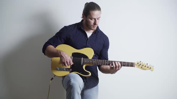 A Man with a Red Beard and Long Hair Plays the Electric Guitar