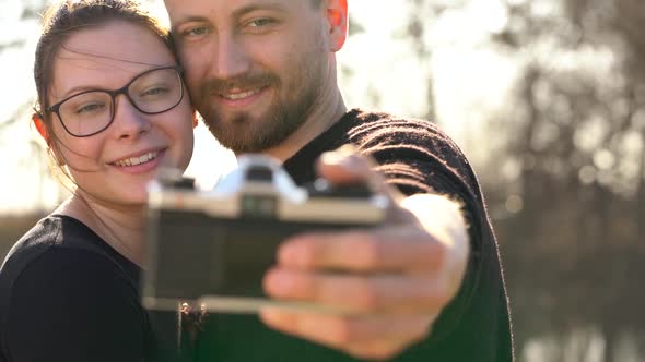 Young Couple in Love Taking Photo of Themself on a Film Camera