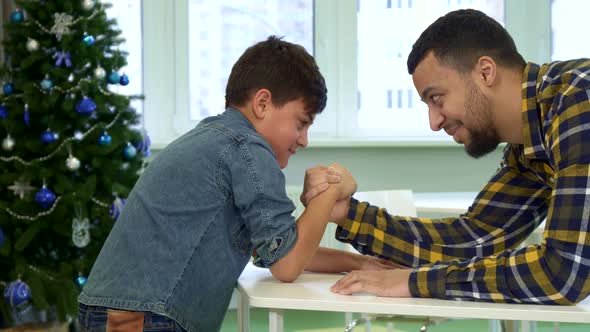 Father and Son Armwrestle on the Table