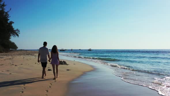 Man and woman suntan on paradise seashore beach voyage by aqua blue sea with white sandy background 