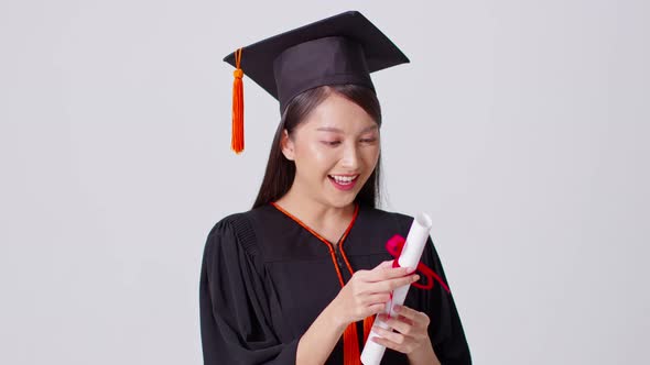 Beautiful Attractive Asian woman graduated in cap and gown smile