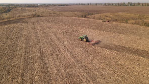 Drone View of Tractors Plowing Farm Field