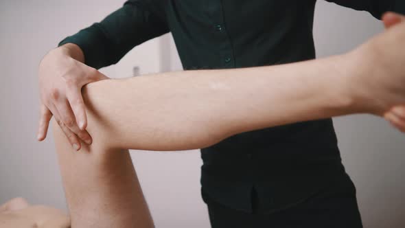 Young Man Having His Knee Examined By Specialist. Physiotherapy Knee Flexibility