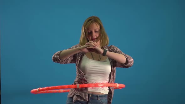 Girl Twists a Hoop on a Blue Background Slow Mo