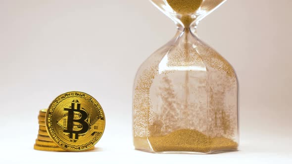 Bitcoin Stands By Sandglass with Pouring Gold Sand Macro