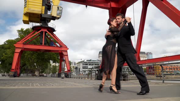 Couple of sexy tango dancers doing a difficult routine under the cranes of Puerto Madero neighborhoo