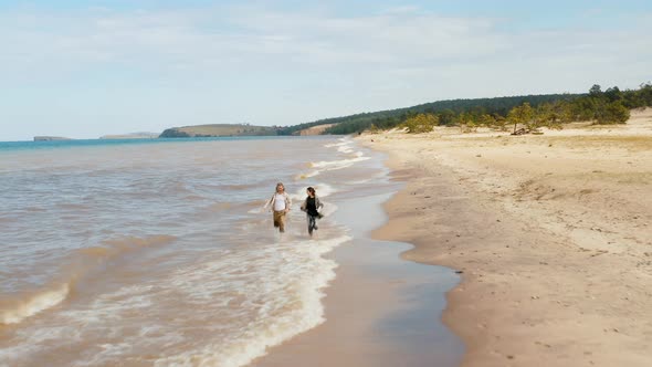 People are running on the water beach Summer Baikal lake Olkhon island