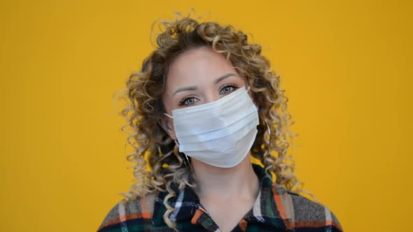 Beautiful Girl Face with Curly Hair in a Protective Medical Mask