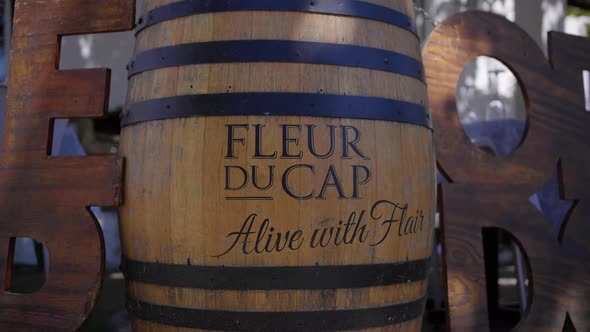 Brown wooden wine barrel with black lines in writing on side walk in front of restaurant, street fil