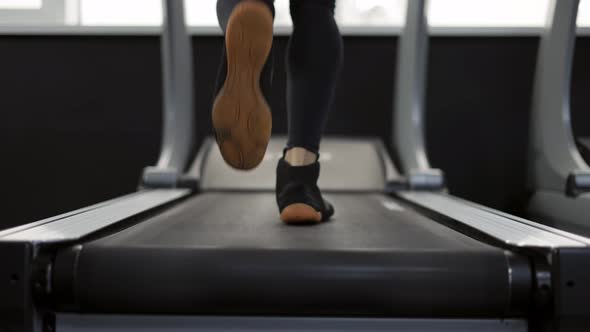 Closeup of Legs Man Jogging on Treadmill in Gym Slow Motion