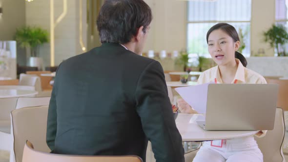 asian businessman and woman discuss together with laptop in modern office design