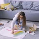 Woman Draws Abstract on Paper on Floor in Room - VideoHive Item for Sale