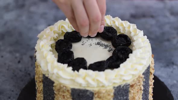 Unrecognizable Woman Pastry Chef Decorates Cake with Poppy Seeds