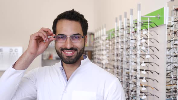 Optician Doctor Near Showcase With Eyeglasses At Glasses Shop