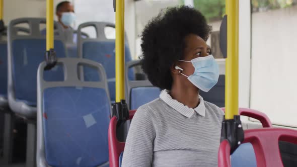 African american businesswoman with face mask sitting in bus