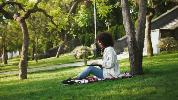 Afro American Girl with Headphones on Neck in Casual Outfit