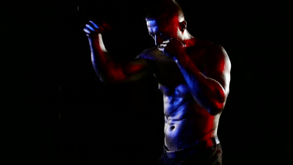 a Muscular Man with a Bare Torso and Golden Metallic Skin is Boxing Against a Dark Background