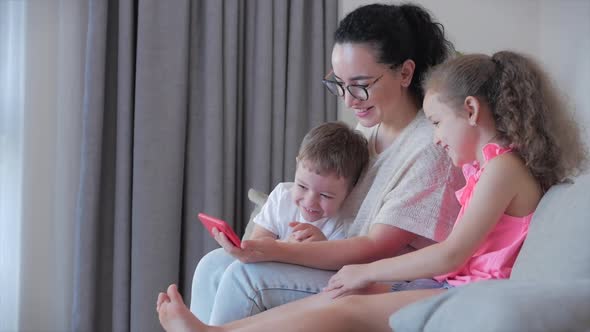 Happy Family,mom and Cute Little Kids,mother Playing with Children at Home Relaxing Use a Smartphone