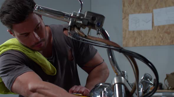 Slow Motion, Man Fixes a Motorcycle in the Garage