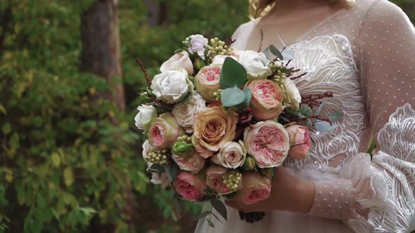 Woman Bride in Wedding Dress Holds Beautiful Bouquet Roses of Different Colors