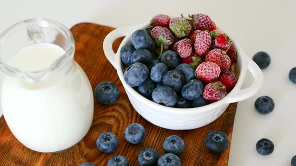 Cup with Ripe Blueberries and Strawberries Glass Jar with Greek Yogurt on Table