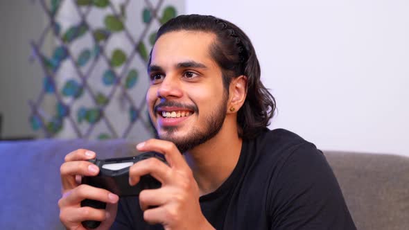 Happy Indian playing video games late at night