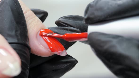 Applying a Layer of Red Varnish to the Nail Surface