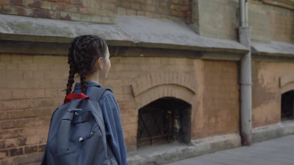 Back View of Little Girl Walking Around the Street Near School in Jeans Jacket