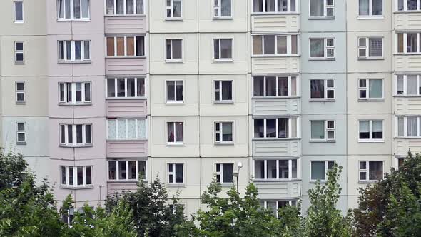 Windows Of A Multi Storey Panel Building. At The Bottom Of The Frame, The Tops Of The Trees