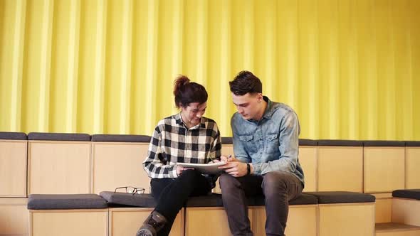 Two Attractive Young People Enjoy Their Time Together Drawing in a Notepad