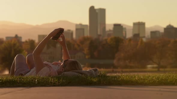 Woman Reading News While Laying on a Grass in the Denver City Park