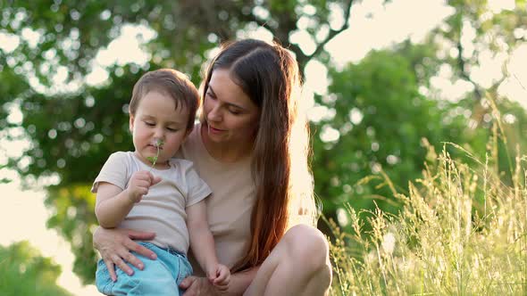 Happy Mother with Her Little Smiling Son in Garden