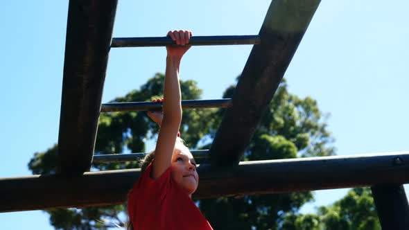 Girl climbing on monkey bar in the boot camp