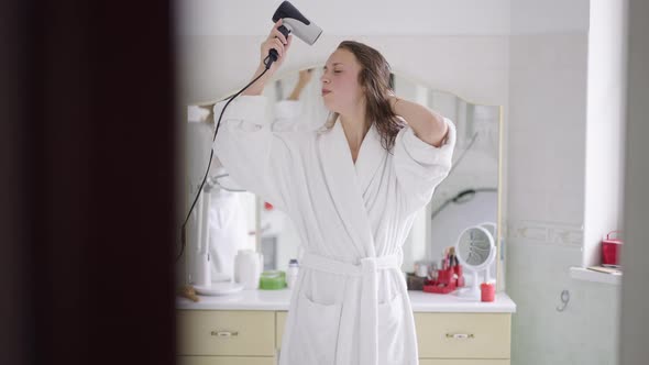 Portrait of Slim Happy Woman Singing Dancing Drying Hair with Hair Dryer in Slow Motion