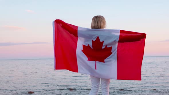 Back View Woman in Summer Clothes with National Canada Flag Outdoors Ocean Sea Sunset Canada Flag