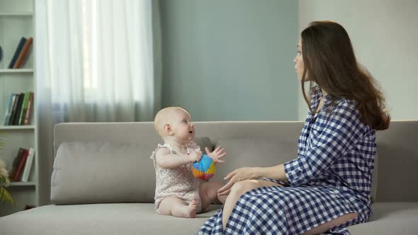 Young Woman Enjoying Motherhood Playing With Active Baby Happiness