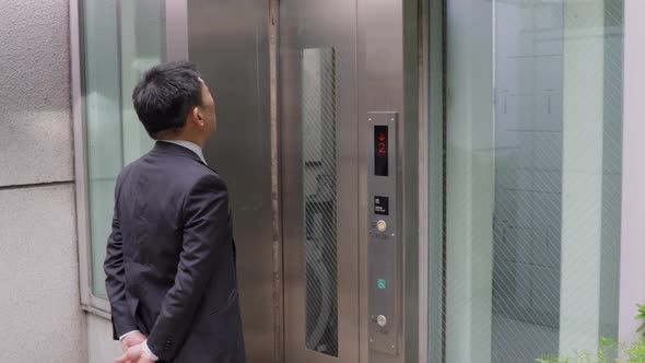 Japanese businessman taking an elevator