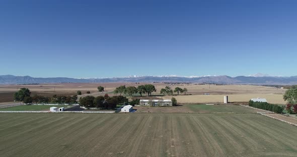 Rocky mountain farm with backdrop of majestic mountain views. Truly beautiful day with no clouds.