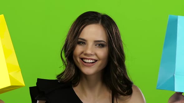 Girl Closes Her Face in Two Packets, Peeks Out From Behind Them and Hides, Green Screen, Close Up