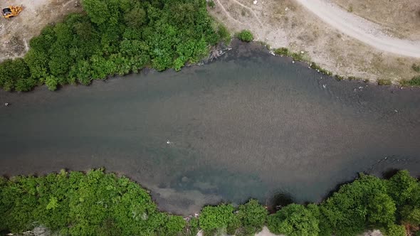 Lowering Drone Shot above a man Fly Fishing in the Provo River in the Mountains of Utah.